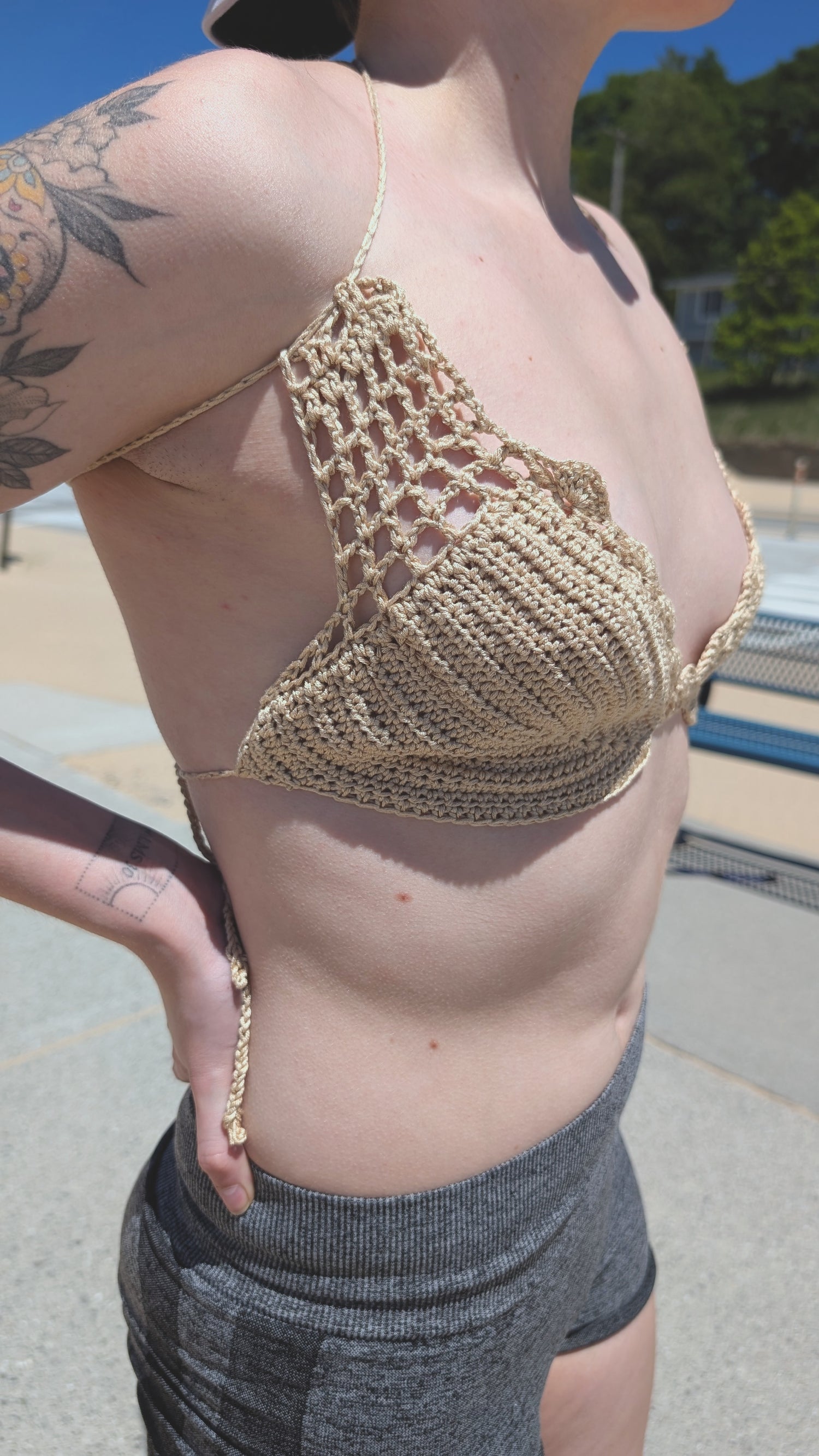 Person wearing a cream bikini top on a beach