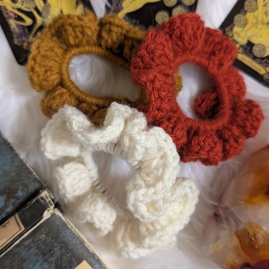 Set of three handmade crochet scrunchies in rust, mustard, and cream